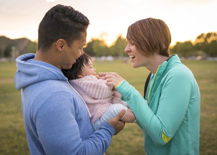 Couple playing with baby in park